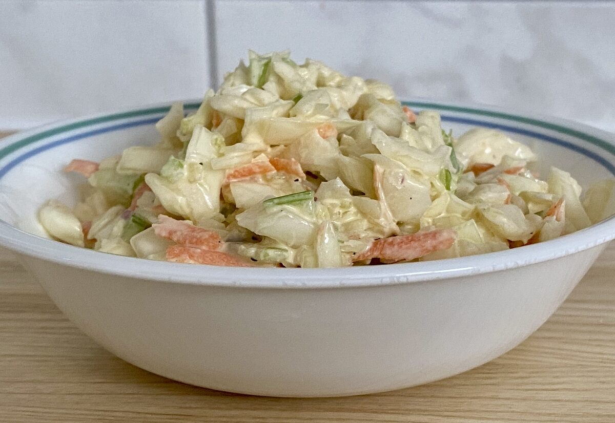 Salade de choux crémeuse avec chou blanc râpé, carotte, céleri et oignon rouge
